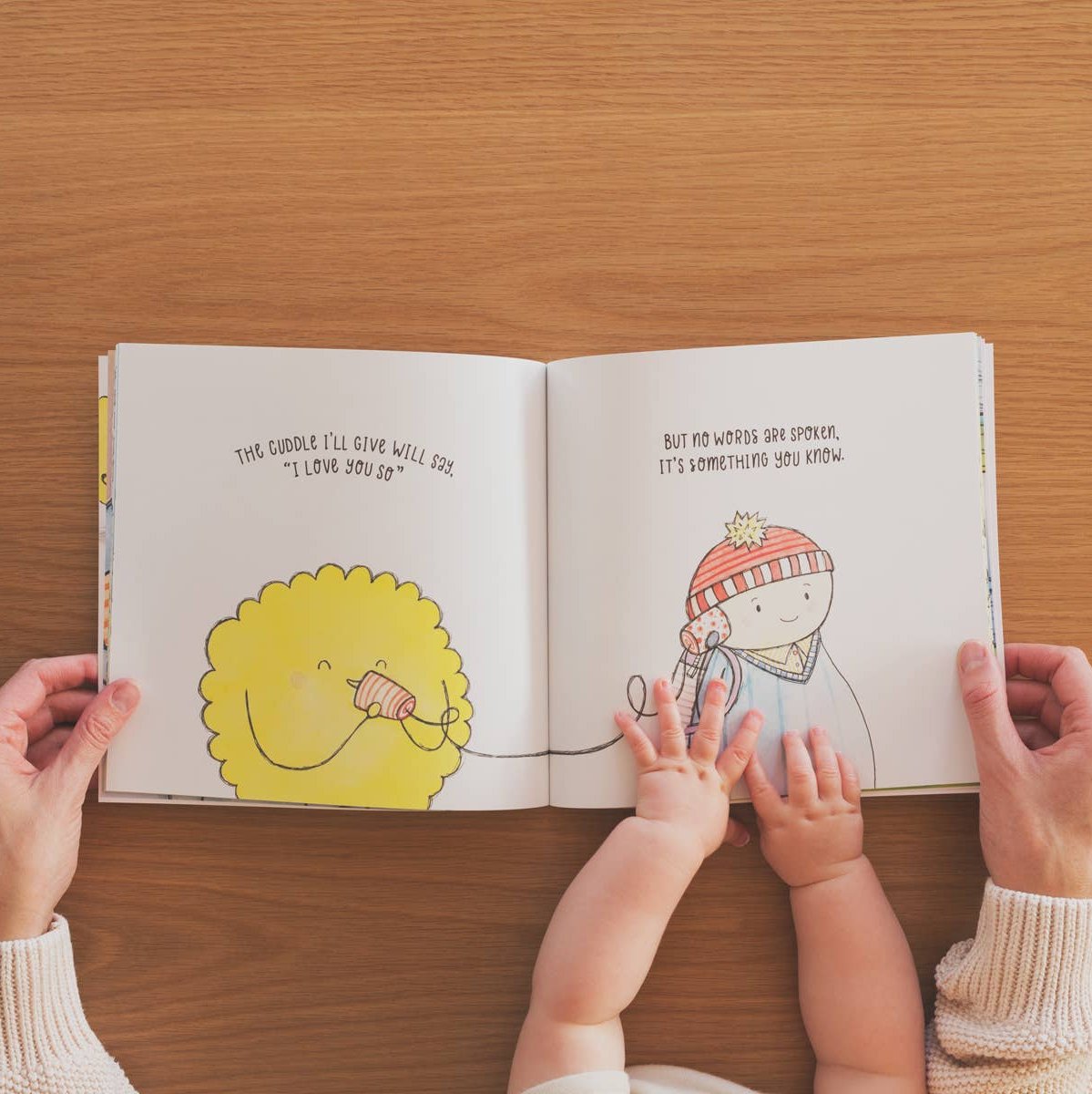 A hardcover children’s book titled The Gift of a Cuddle, featuring a whimsical cover illustration of a child nestled with a parent.